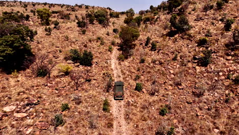 truck drives laboriously up steep rocky mountain slope on 4x4 route