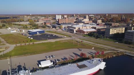 aerial view of ship on river, streets and buildings in muskegon, mi