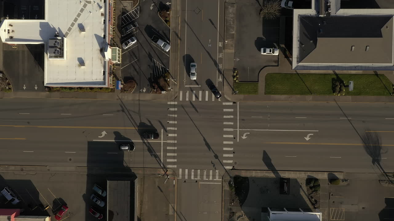 자동차는 화창한 날 도시 경관에서 교통 정지 신호등이 있는 4방향 교차로를 통과합니다.