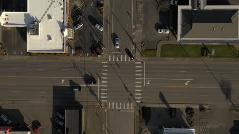 Los-Autos-Conducen-A-Través-De-Una-Intersección-De-Cuatro-Vías-Con-Semáforos-En-El-Paisaje-Urbano-Durante-El-Día-Soleado