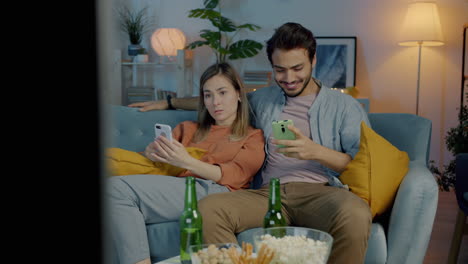 couple relaxing at home with smartphones