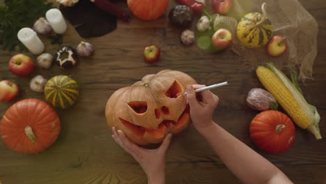 concepto de halloween. vista superior de la mujer tallando calabaza