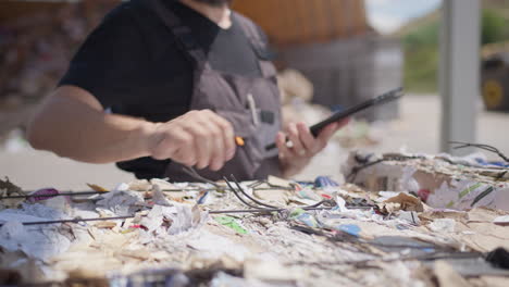 unrecognizable worker controls paper bale at recycling plant, close-up