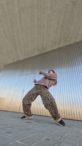 young urban dancer performing outside modern building
