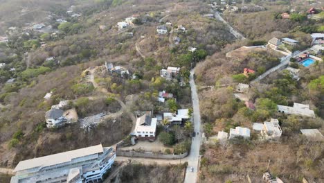 Tire-Del-Movimiento-De-Vuelo-Frontal-Sobre-Las-Pequeñas-Casas-De-La-Ciudad-Costera-De-Puerto-ángel-En-Oaxaca,-México-Por-La-Mañana