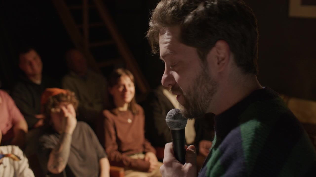 Comico che fa ridere il pubblico durante uno spettacolo di stand-up sul palco