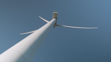 a wind turbine spins on a sunny day