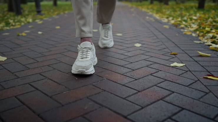Man feet walking in autumn park