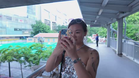 woman taking photo of cityscape from overpass