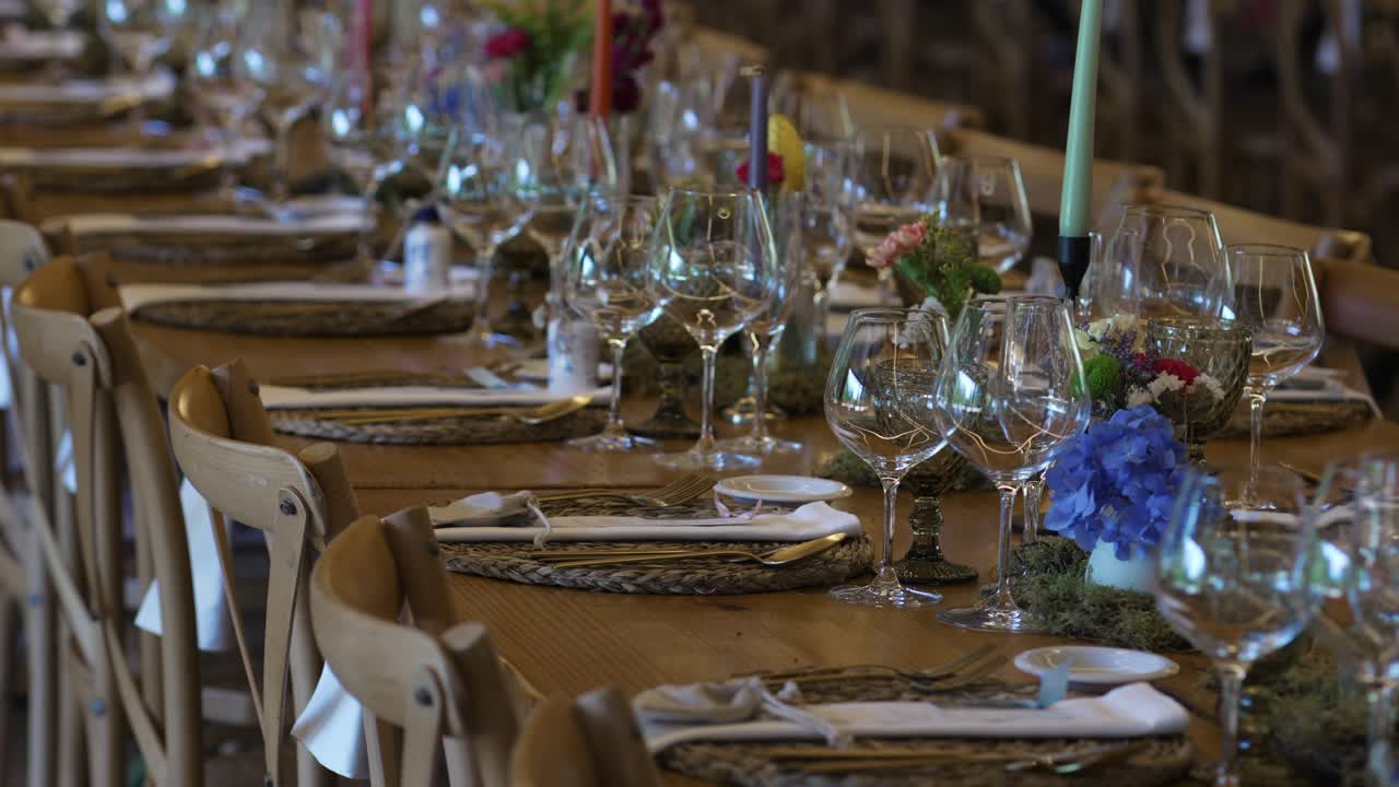 Long rustic table set with glassware and flowers for wedding dinner location irrelevant