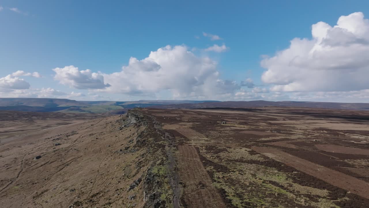 imágenes aéreas de drones dando vueltas sobre una espectacular formación rocosa en un gran páramo británico abierto en un hermoso día de otoño