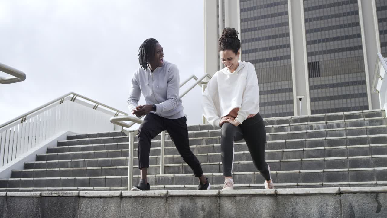 When stepping onto stairs Diverse friends warming with lunges, stretches and swings sharing glance