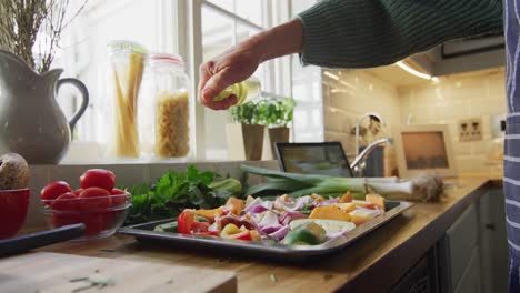 midsection of senior caucasian woman standing in kitchen and preparing dinner