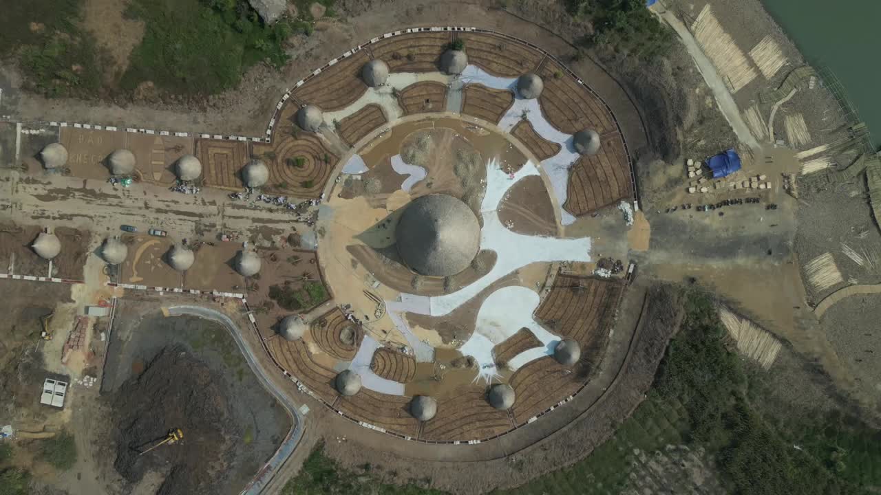 Aerial view of an innovative dome structure with radial layout under construction, showcasing modern architecture near a waterfront with surrounding land development zones.