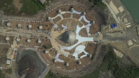 aerial view of an innovative dome structure with radial layout under construction, showcasing modern architecture near a waterfront with surrounding land development zones.