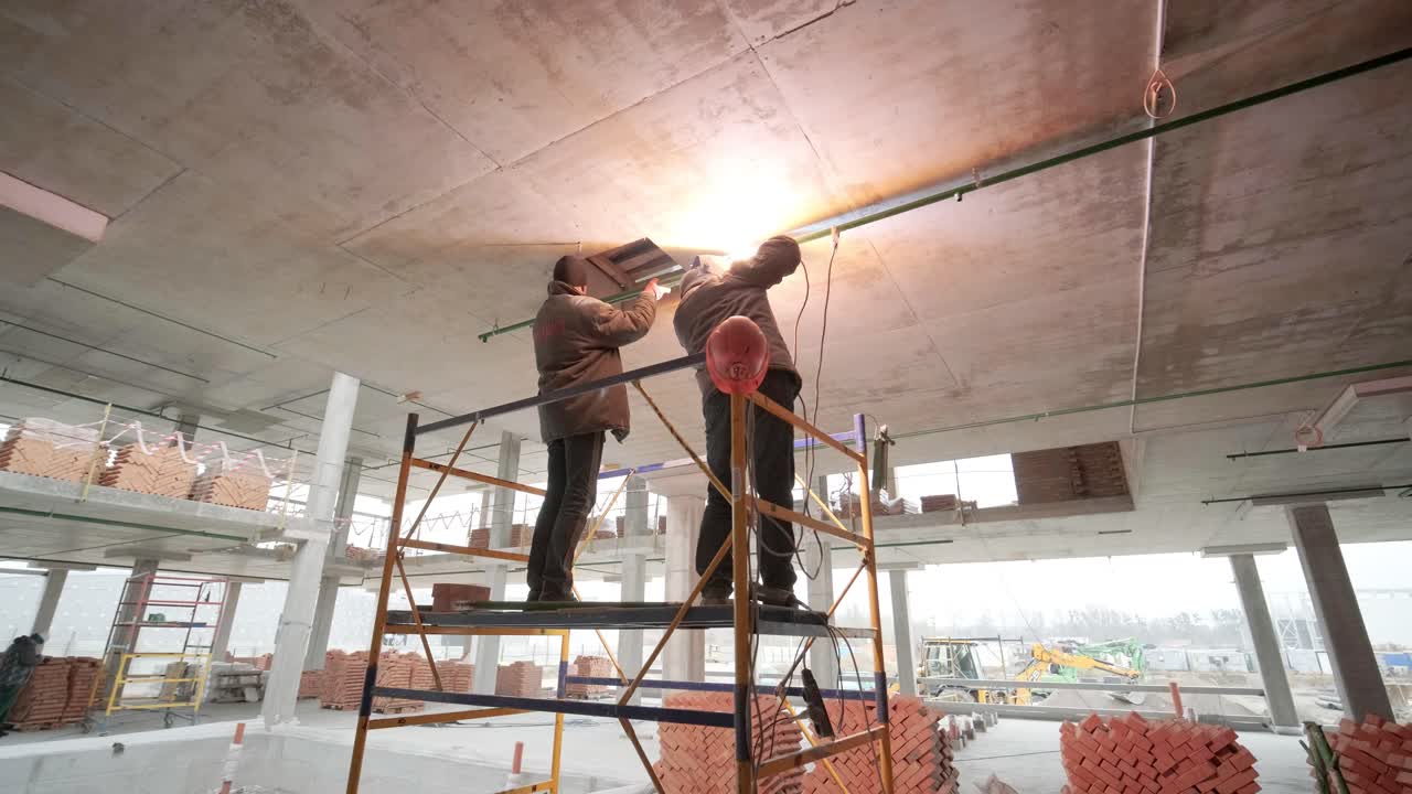 los trabajadores profesionales instalan tuberías de alcantarillado o de suministro de agua en una fábrica moderna. construcción de una fábrica, hangar