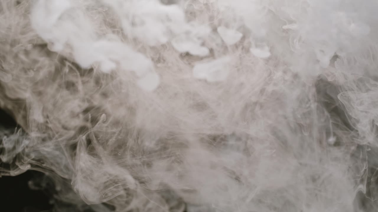 Abstract White Smoke Spreading and Swirling on Black Background