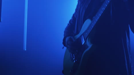 guitarist on stage in blue light