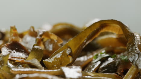 japanese wakame chuka fermented food. close-up on a detail of hiyashi wakame chuka or seaweed salad or seaweed with sesame seeds on a plate. top view. seafood background. health concept.