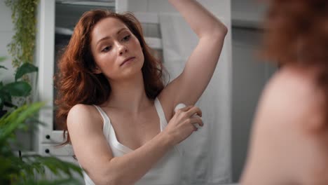 Redhead-woman-applying-antiperspirant.