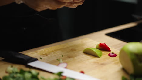 close-up of hands slicing fresh produce on a cutting board