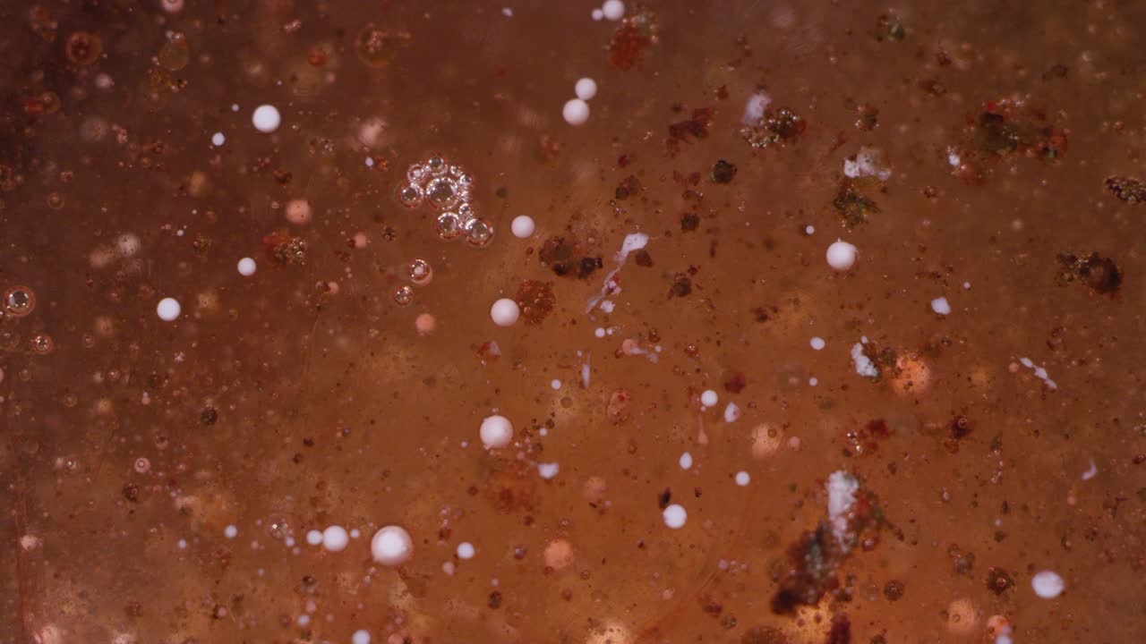 거친 부풀어오르는 갈색과 오렌지색 액체의 거시 촬영. 거시 추상 텍스처 배경