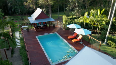 Terraza-Panorámica-De-La-Piscina-Con-Velas-Flotantes-Preparadas-Para-El-Evento,-Paso-Elevado-De-Drones-De-4k