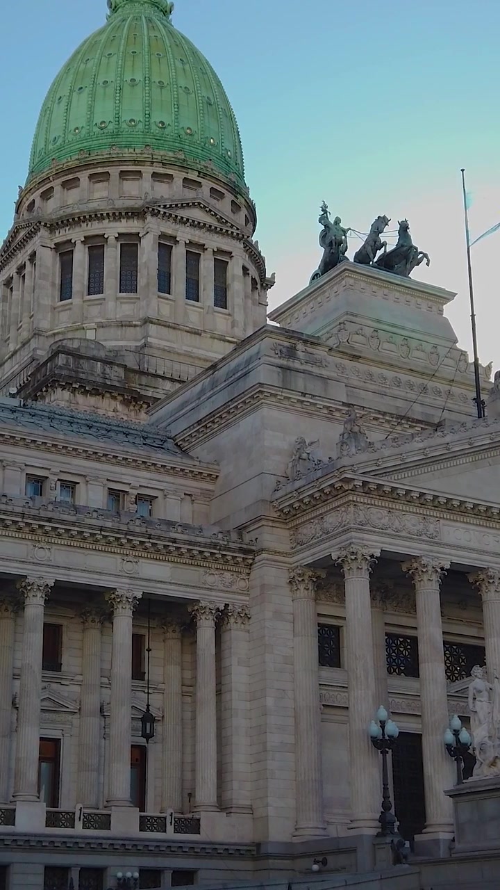 Ripresa verticale dal basso in slow motion del Palazzo del Congresso Nazionale Argentino con bandiera sventolante a Buenos Aires
