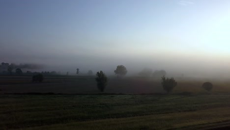 tuscan countryside fields in italy as sun rises on a cold foggy morning, aerial dolly in reveal shot