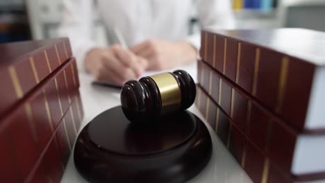 lawyer writes in notebook next to gavel of judge