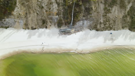 un dron aéreo disparó sobre la playa del mar báltico con una escalera que bajaba por los acantilados hasta la costa del océano