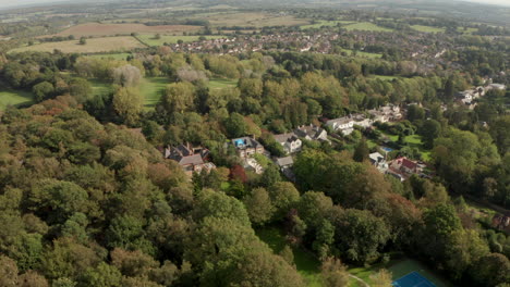 Aufsteigende-Luftaufnahme-über-Dichtem-Wald-In-Richtung-Der-Kleinen-Englischen-Stadt-Theydon-Bois