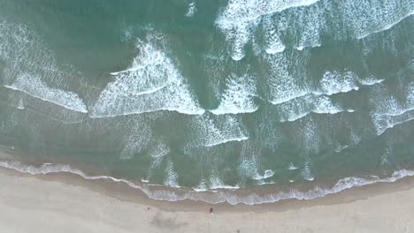 Toma-Aérea-De-Drones-De-Grandes-Olas-De-Surf-Y-Surfistas-Remando-En-La-Costa-Cantábrica,-Playa-De-Meron