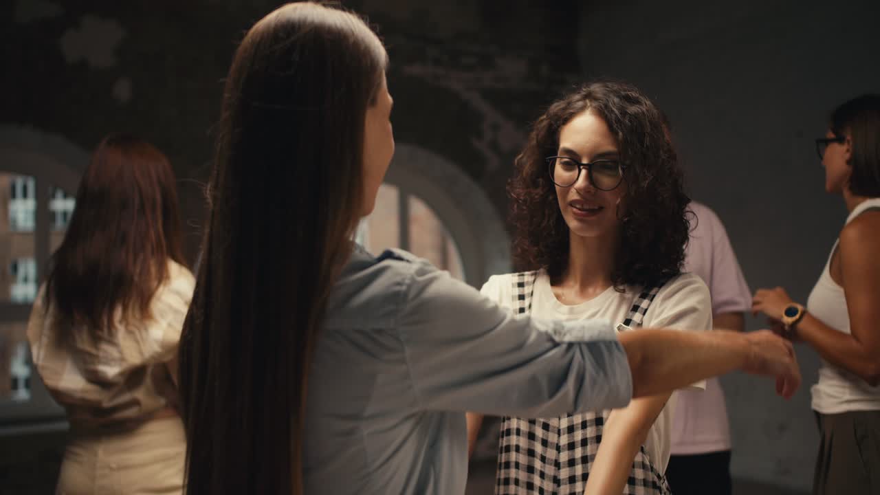 una chica con cabello rizado con gafas se comunica con una chica con cabello liso largo en terapia de grupo y se abrazan. logrando una comprensión mutua y una comunicación agradable en terapia de grupo