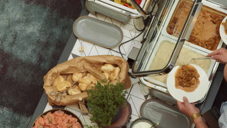 The-view-from-above-of-the-buffet,-and-the-people-picking-up-their-food