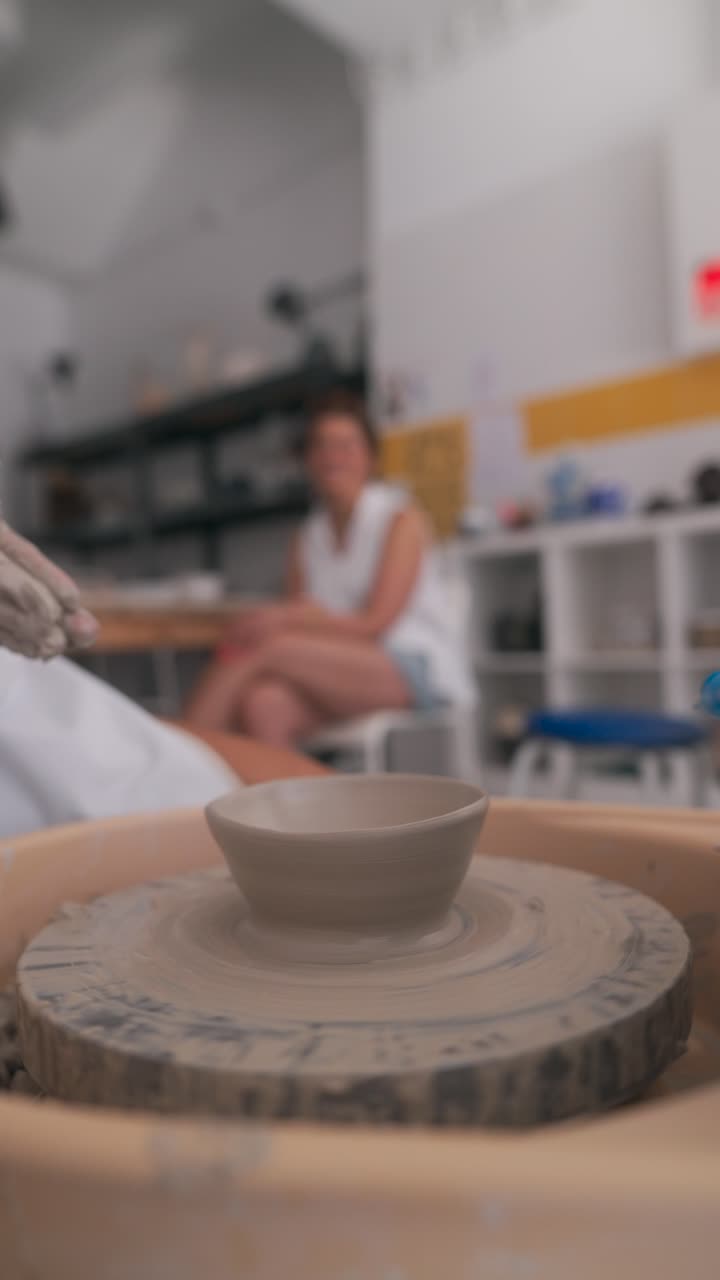 Close-up of Hands Shaping Clay on a Pottery Wheel in a Creative Workshop