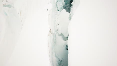 snowy swiss glacier split by a deep crevice, aerial view of jungfraujoch area