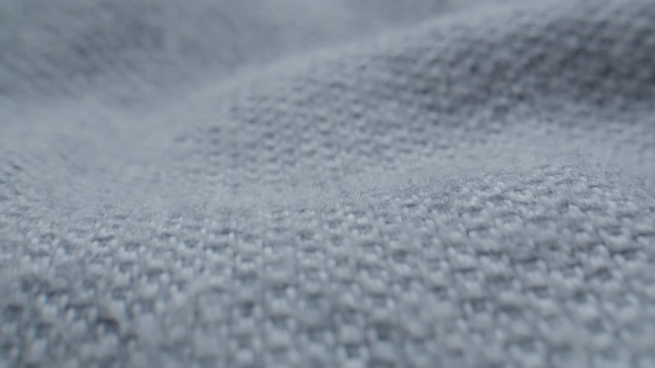 Human Finger Gently Touching and Feeling Grey Knitted Fabric