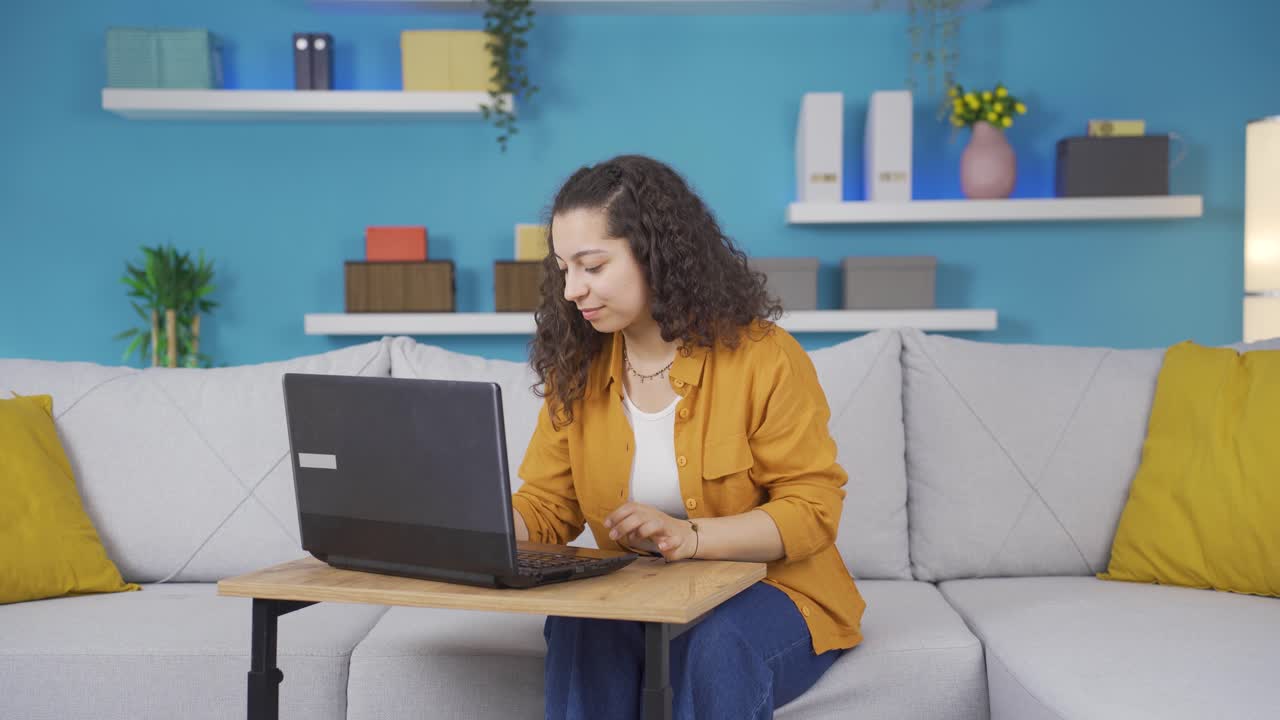 mujer joven trabajando en una computadora portátil con expresión feliz.