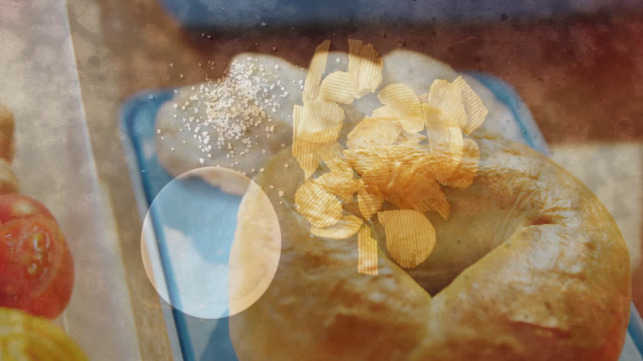 Golden potato chips and salt animation over freshly baked bread on blue plate