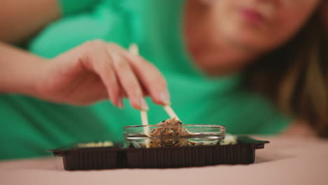 woman eating sushi lying down