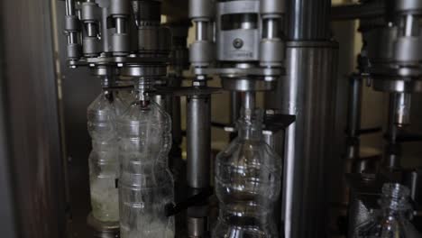 Plastic-Bottles-Rotating-on-an-Automated-Machine-at-a-Factory-Being-Filled-with-Fresh-Vinegar