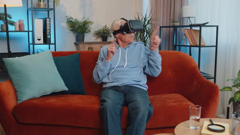 hombre mayor usando realidad virtual tecnología futurista auriculares jugar simulación 3d videojuego en casa