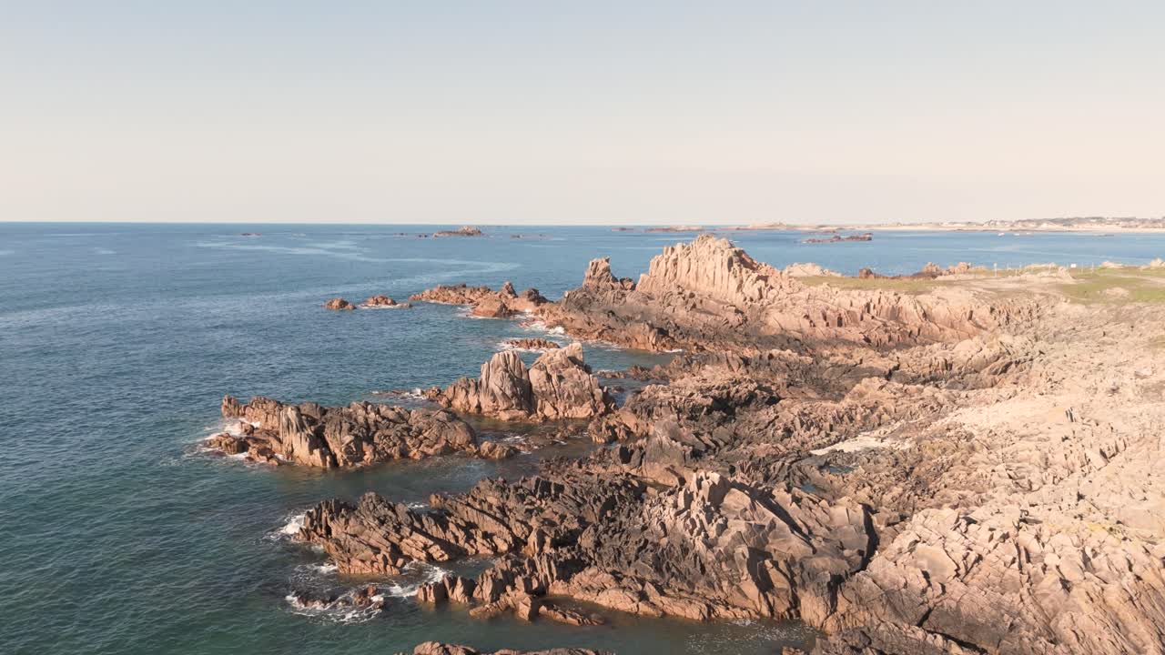 imágenes de aviones no tripulados de la costa noreste de guernsey que muestran la costa, las rocas, los promontorios con aguas cristalinas en un día de almejas brillantes.