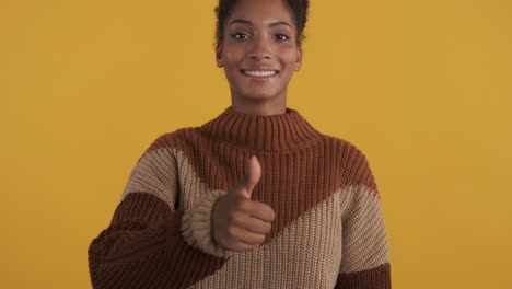 mujer negra feliz dando el pulgar hacia arriba