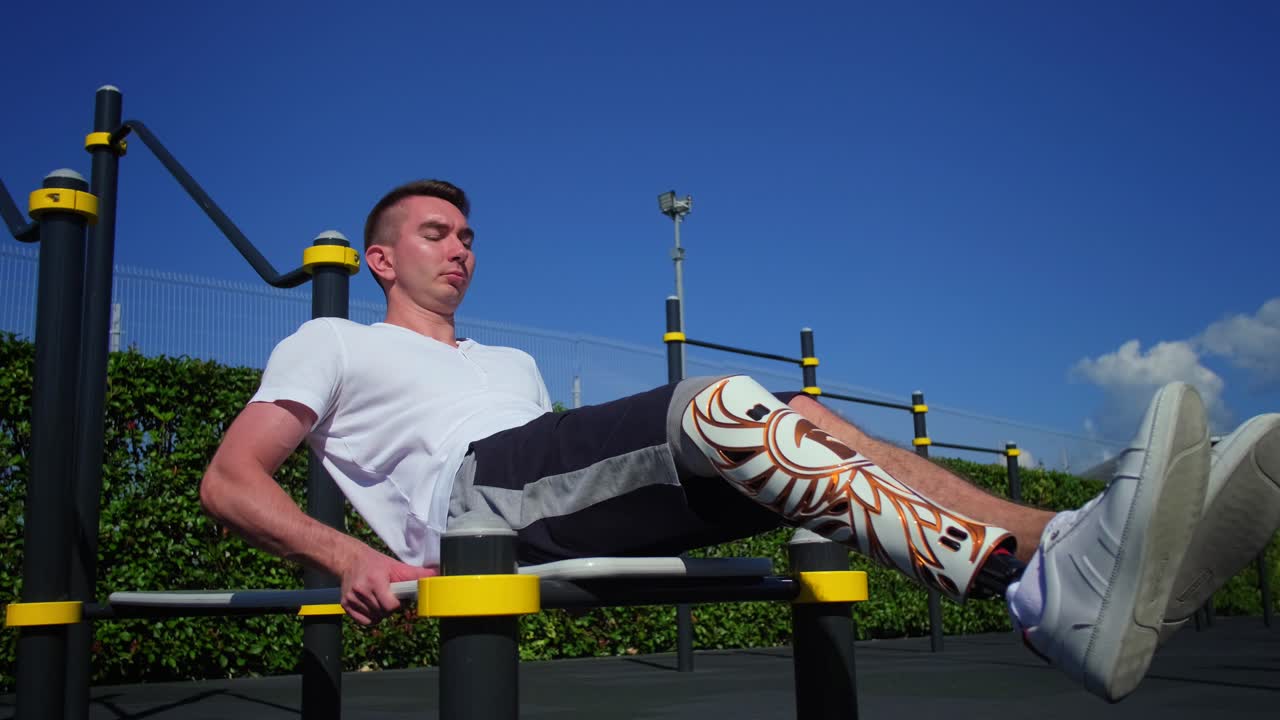 hombre con una pierna protésica haciendo ejercicio en un gimnasio al aire libre