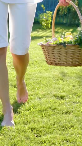 woman carrying a basket of fresh vegetables in a garden