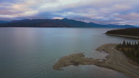Kluane-Lake-at-dramatic-winter-sunset-on-calm-evening,-aerial-drone