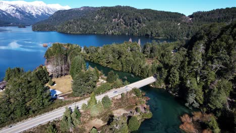 highway road in remote natural landscape with lake and mountains, aerial view