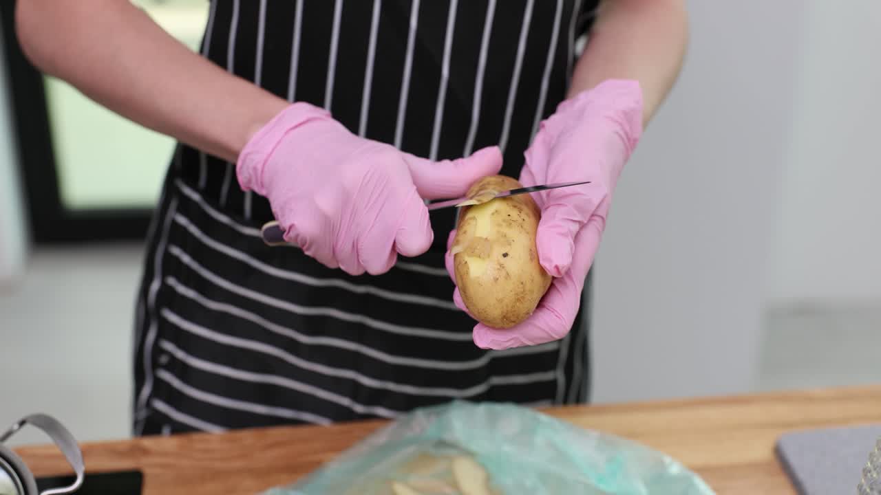 Peeling a potato with gloves
